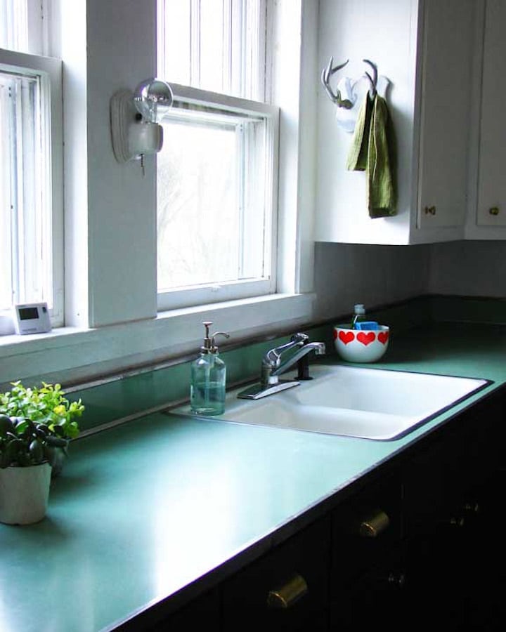A kitchen with a sink and a mirror