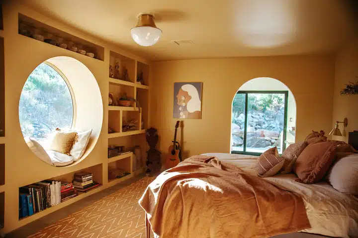 A bedroom with a bed and looking at the camera