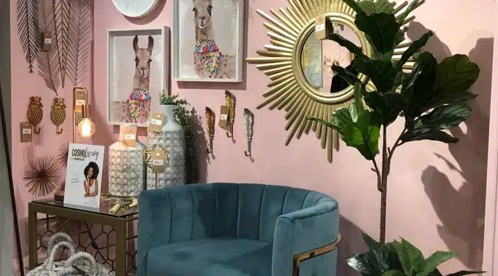 Pink wall with llama paintings on the wall and a turquoise chair