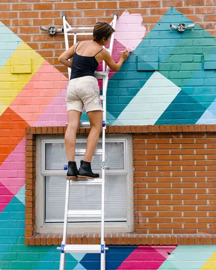 A young girl jumping on a brick building
