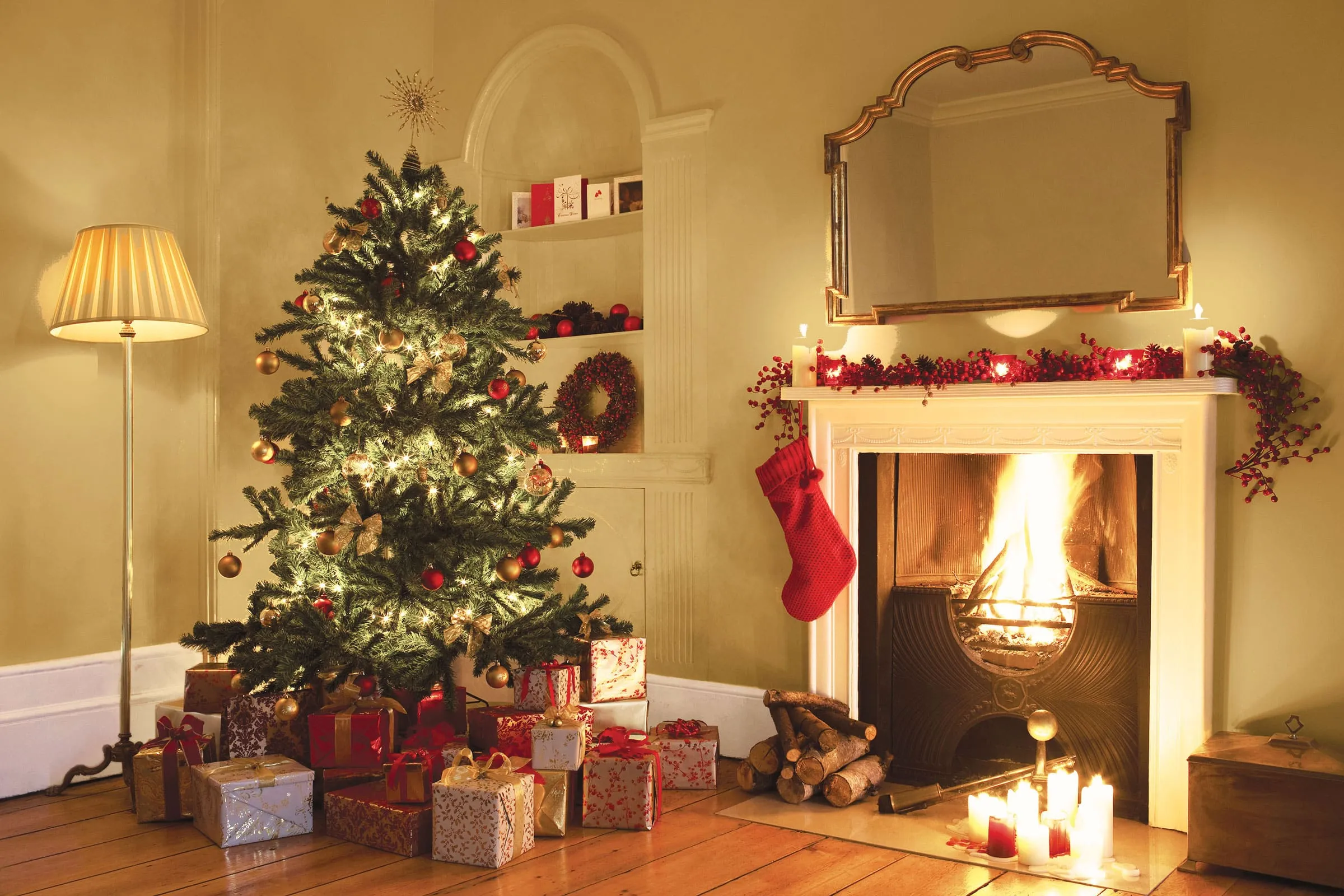 A fire place sitting in a living room with a christmas tree