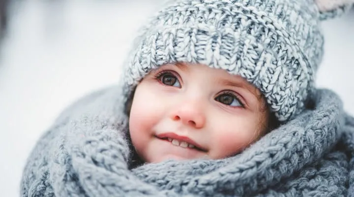 A close up of a baby wearing a hat