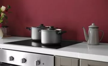 A pot on a stove top oven sitting inside of a kitchen